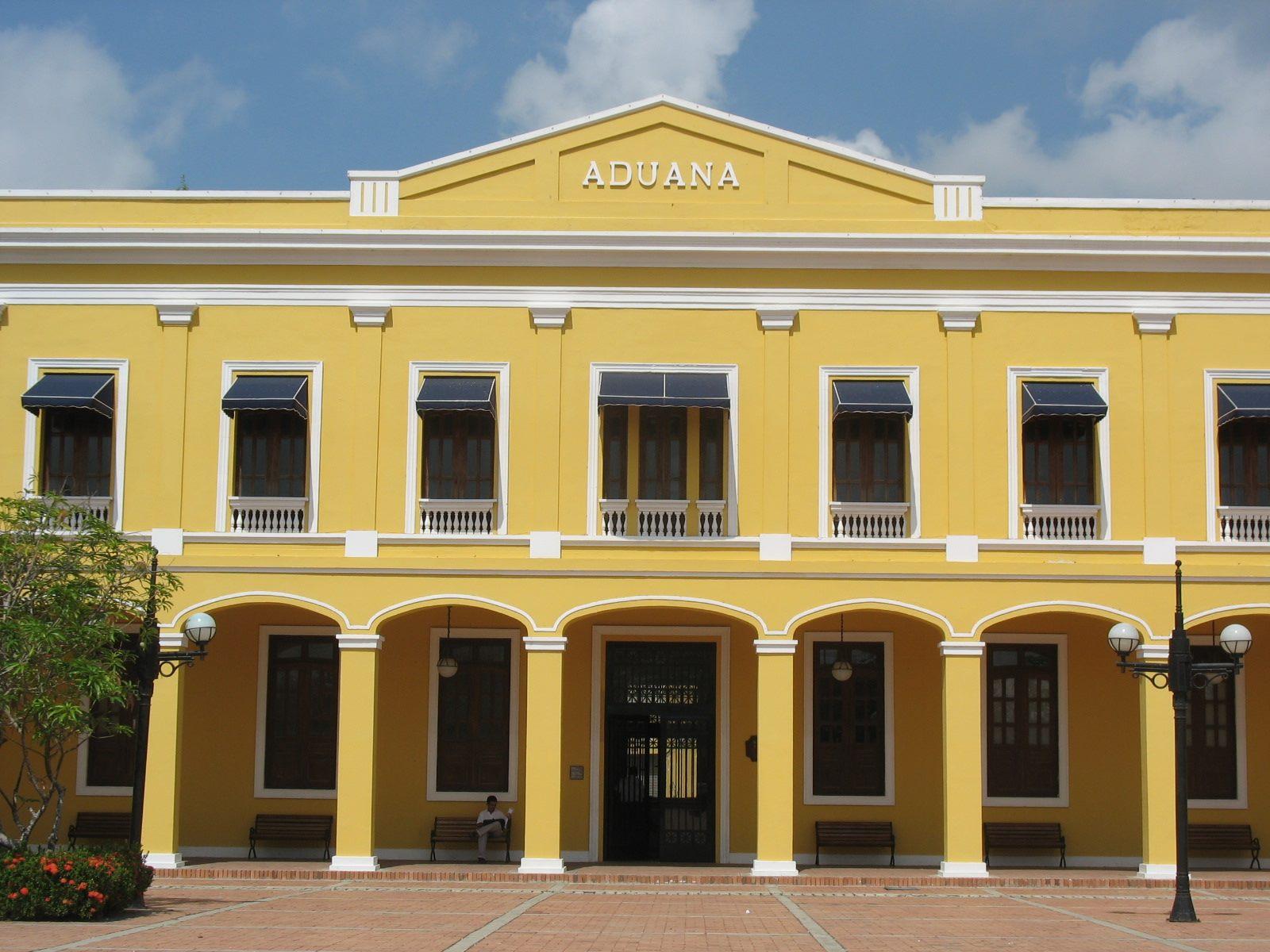Fachada amarilla de la Antigua Aduana de Barranquilla bajo cielo azul.